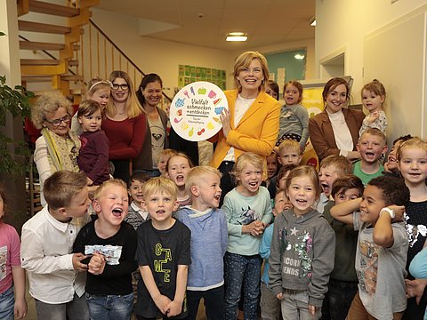 Bundesministerin mit Mitarbeitenden und Kindern der Kita