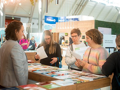 Am IN FORM-Stand: Besucherinnen interessieren sich für Prospekte und Ratgeber. 