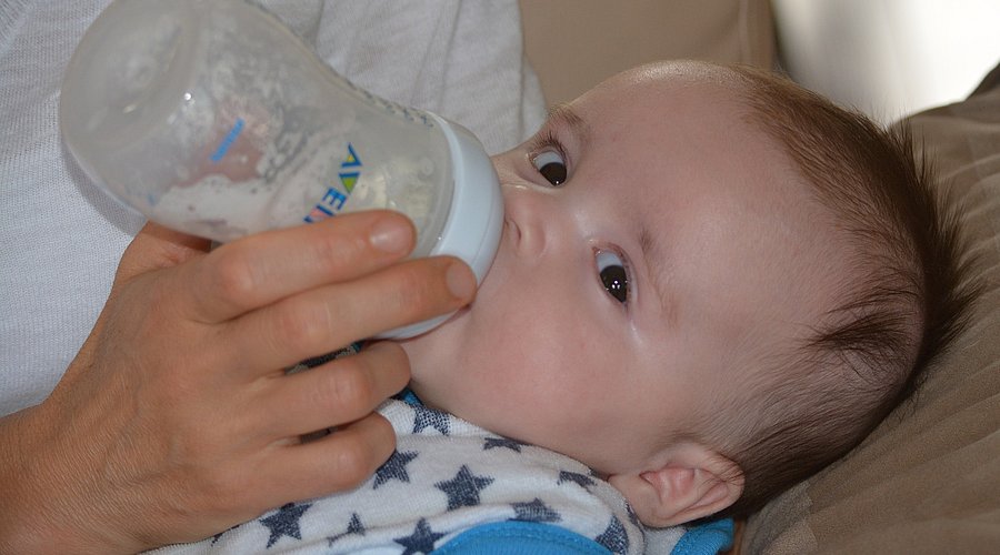 Baby wird mit Flasche gefüttert. 