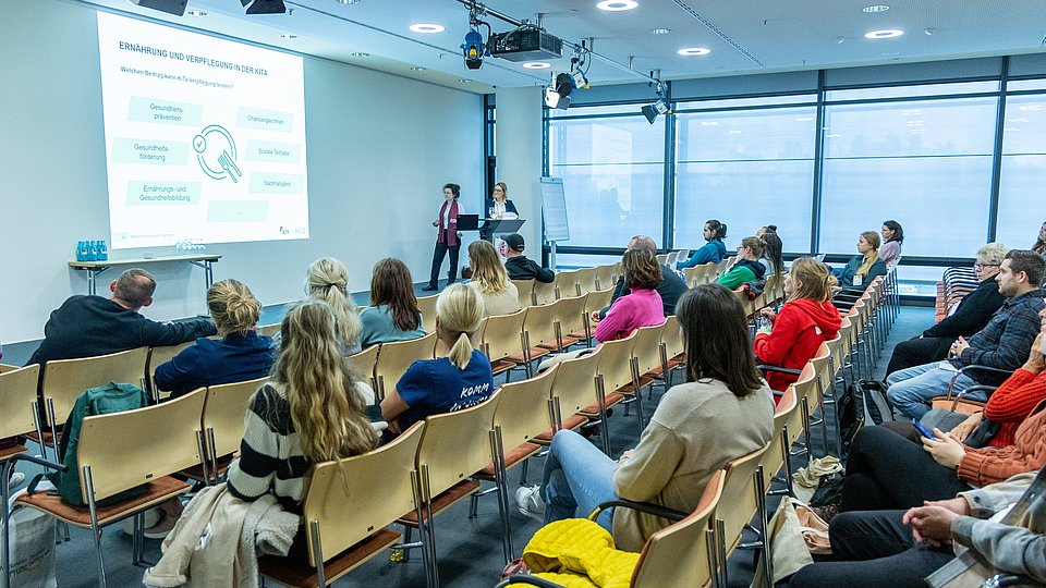 Seminarraum auf der Messe ConSozial 2023 in Nürnberg. Die Referentinnen sprechen vor dem Publikum.