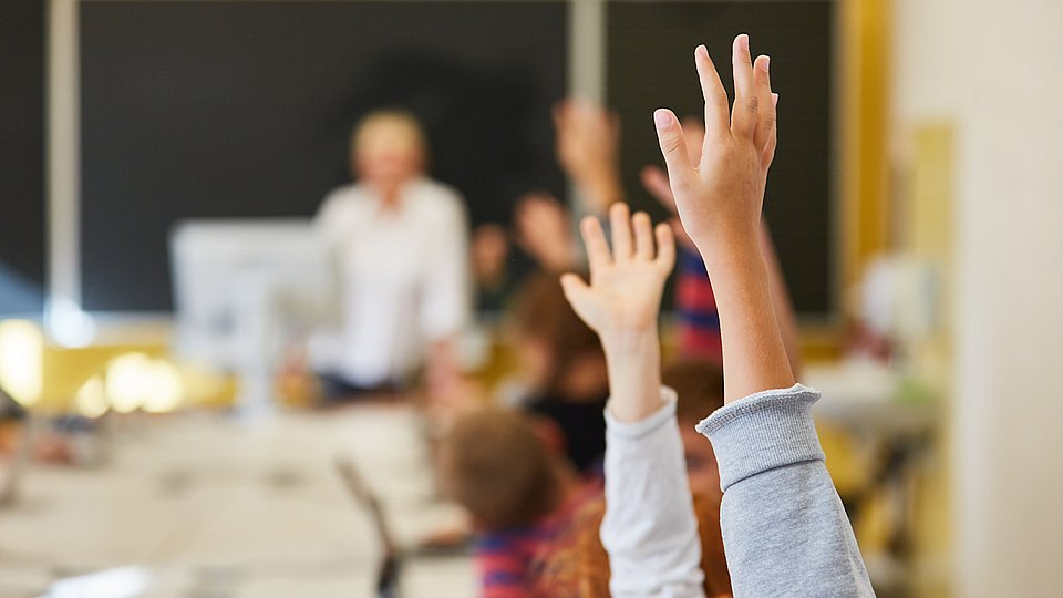 Schüler melden sich im Unterricht