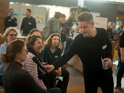 Moderator im Gespräch im Plenum.