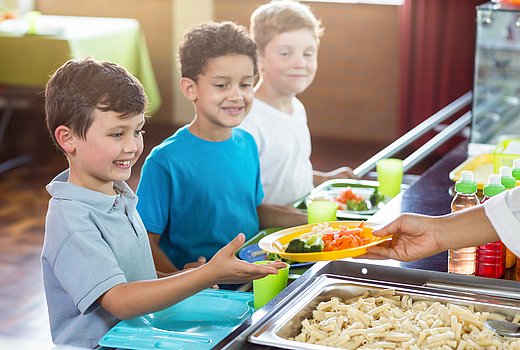 3 Jungen vor der Ausgabe des Schulessens 