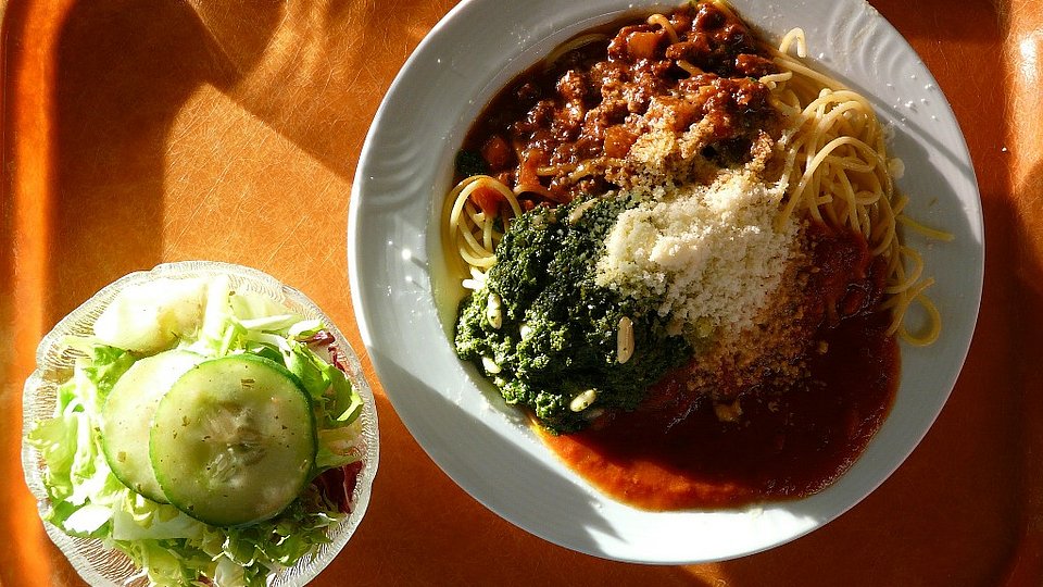 Spaghetti Bolognese mit Salat auf einem Mensatablett