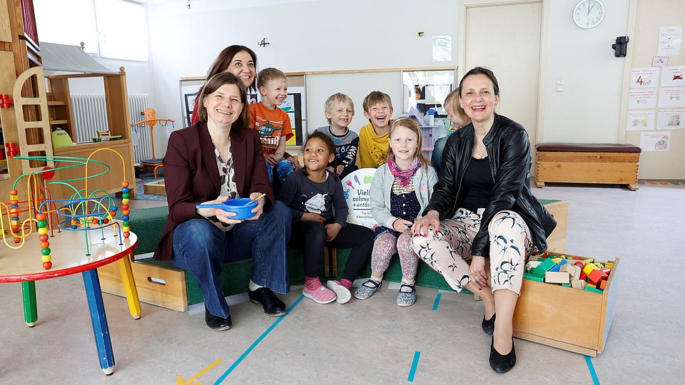 Die Parlamentarische Staatssekretärin beim Bundesminister für Ernährung und Landwirtschaft, Dr. Manuela Rottmann, gemeinsam mit der Parlamentarischen Staatssekretärin bei der Bundesministerin für Familie, Senioren, Frauen und Jugend, Ekin Deligöz (2. v. links), und Anna Heyer-Stuffer, Staatssekretärin im Ministerium für Soziales, Gesundheit, Integration und Verbraucherschutz des Landes Brandenburg (rechts) in der Kita Klein & Groß in Königs Wusterhausen (Brandenburg)