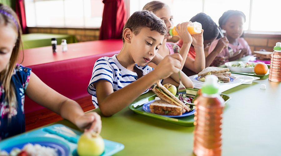 Kinder beim Mittagessen in der Schulmensa