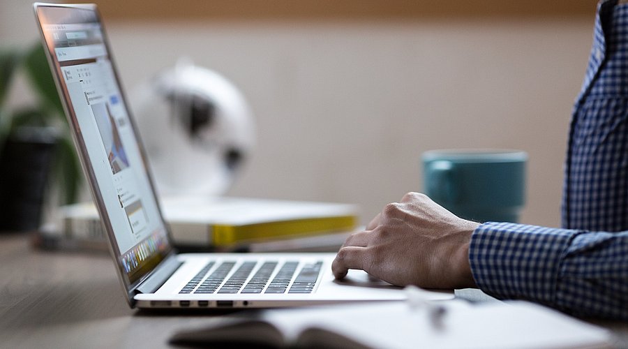 Ein Mann sitzt vor dem Laptop. 