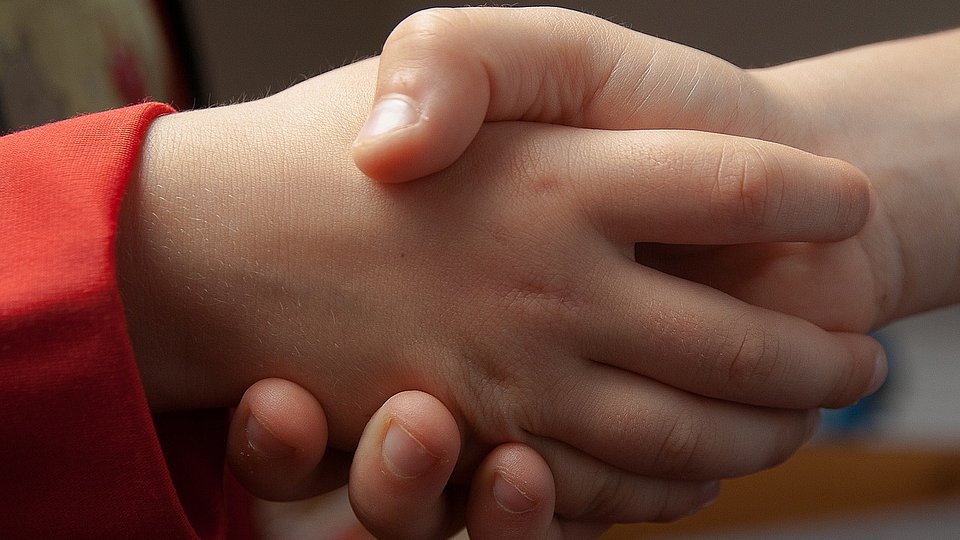 Kinder geben sich die Hand