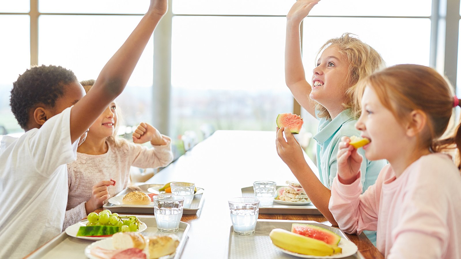 zufriedene Schulkinder beim Mittagessen