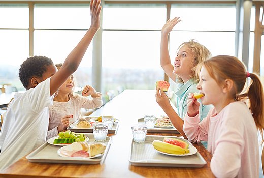 zufriedene Schulkinder beim Mittagessen